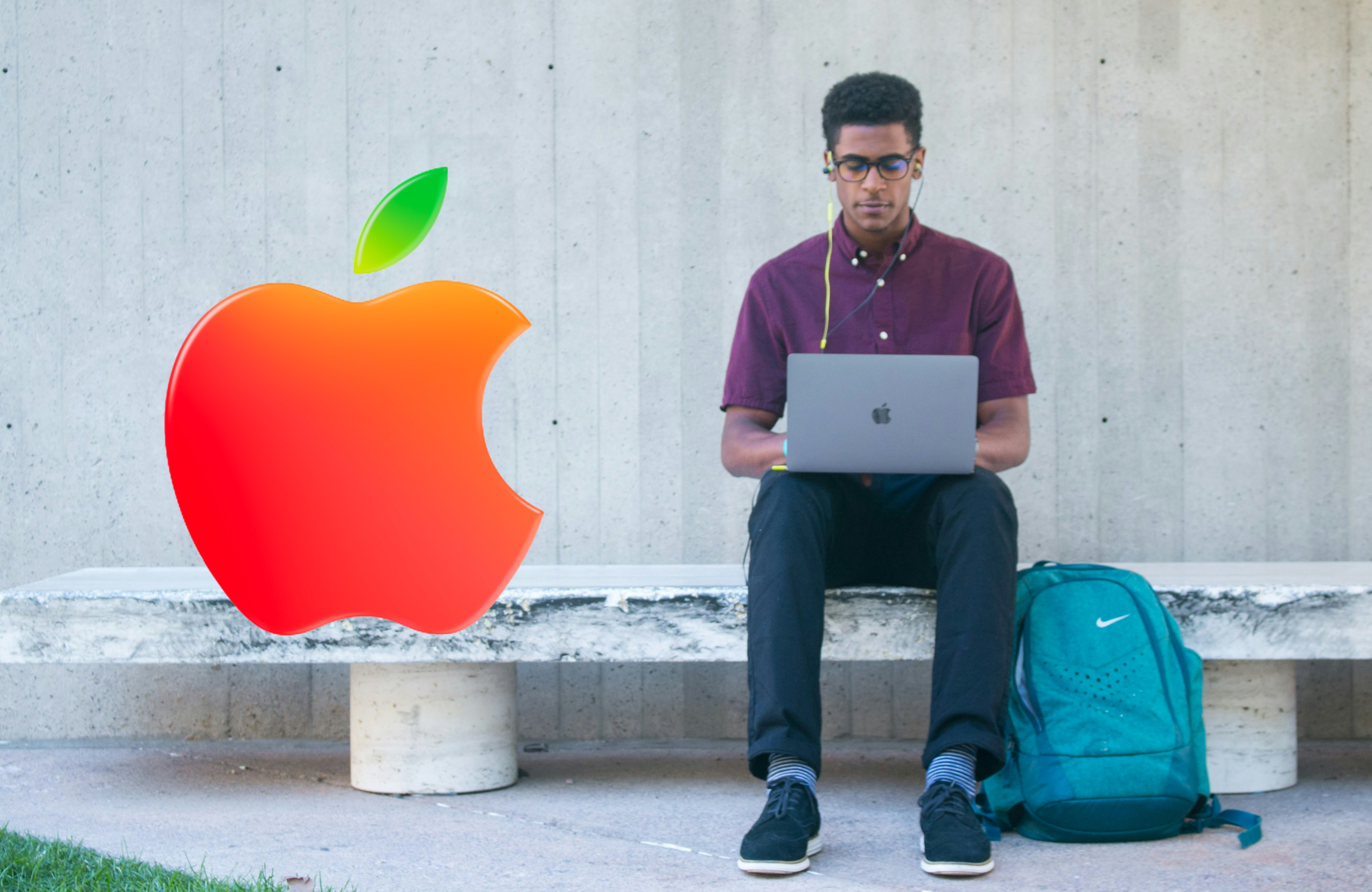 A student sat on a bench with a MacBook