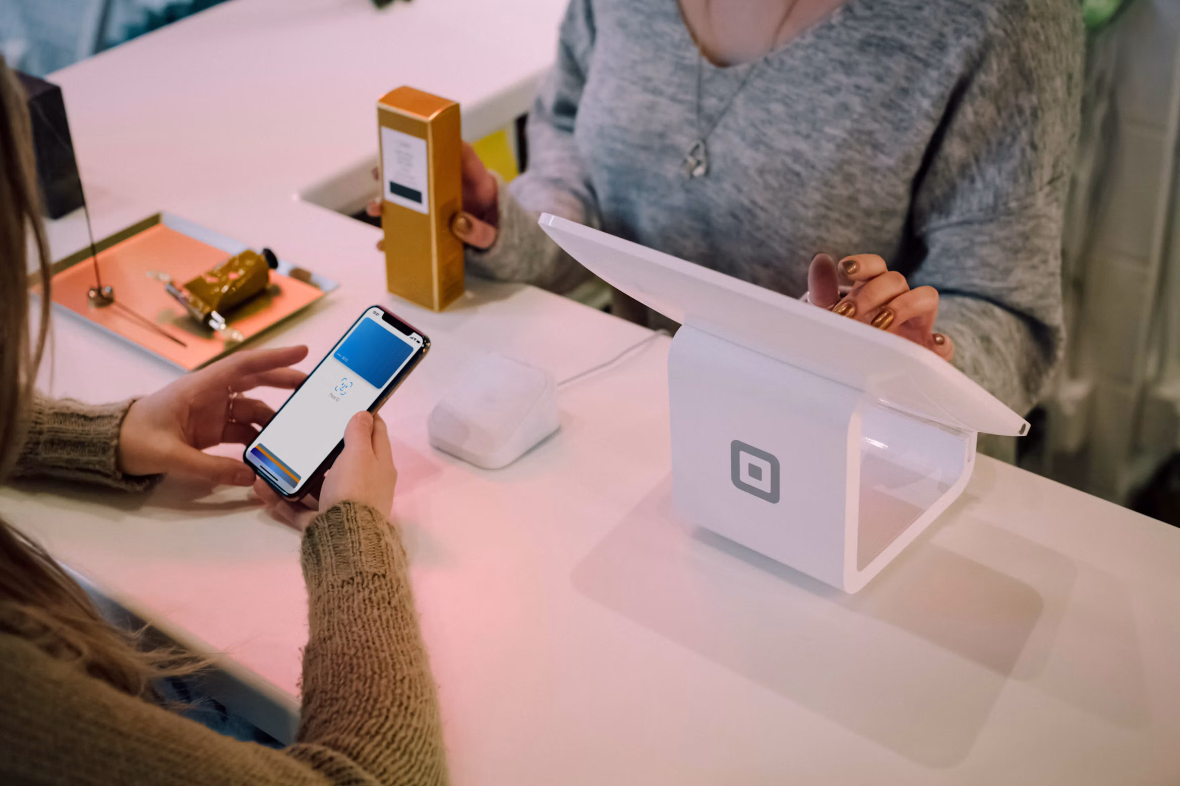 a person paying with Apple Pay at a shop's till
